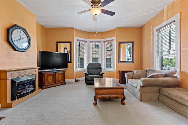 carpeted living room with a textured ceiling and ceiling fan