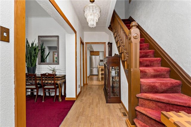 entrance foyer featuring light hardwood / wood-style flooring and an inviting chandelier