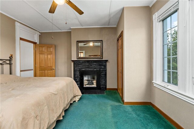 carpeted bedroom with ceiling fan, a fireplace, and ornamental molding