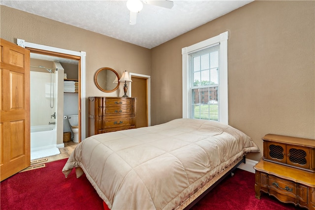 carpeted bedroom with a textured ceiling, ceiling fan, and ensuite bathroom