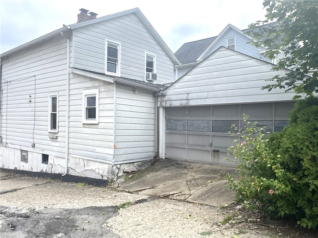 back of house with cooling unit and a garage