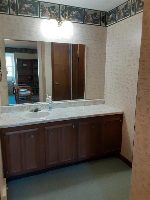 bathroom featuring wallpapered walls and vanity