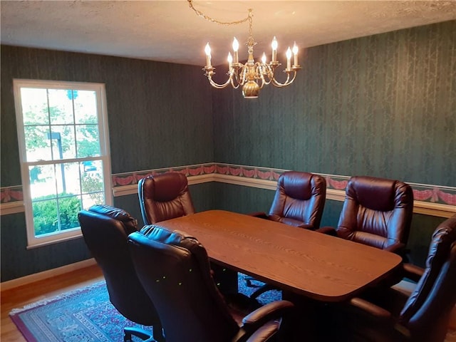 dining room featuring baseboards, a chandelier, and wood finished floors