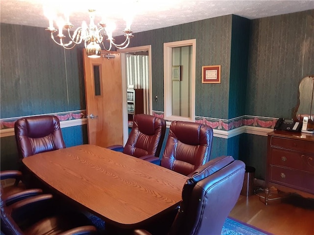 dining space with wallpapered walls and a notable chandelier