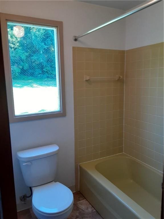 full bath with toilet, tile patterned flooring, and washtub / shower combination