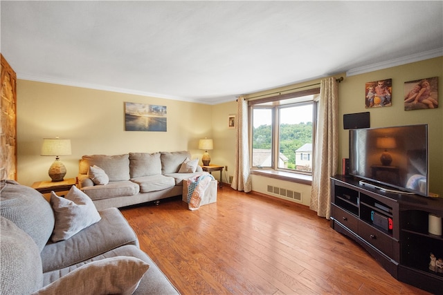 living room with light hardwood / wood-style flooring and ornamental molding