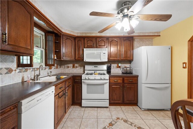 kitchen featuring tasteful backsplash, white appliances, ceiling fan, sink, and light tile patterned flooring