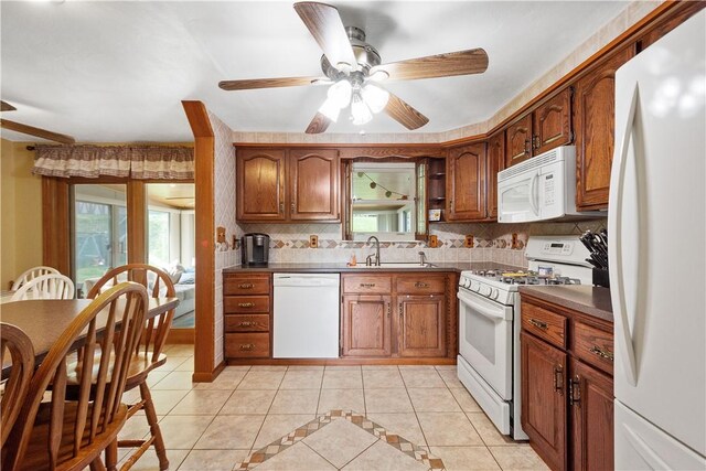 kitchen with backsplash, white appliances, ceiling fan, sink, and light tile patterned floors