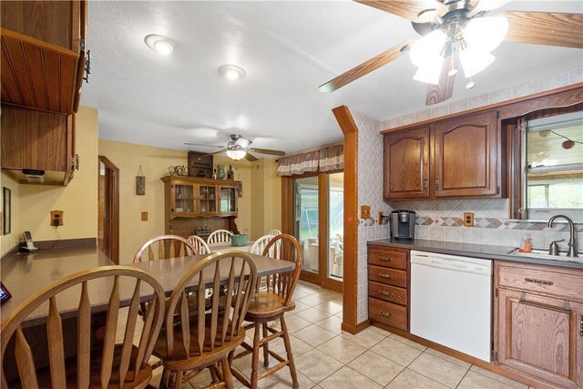 kitchen with dishwasher, light tile patterned floors, a healthy amount of sunlight, and sink