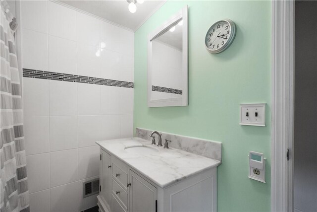 bathroom with vanity, tile walls, and ornamental molding