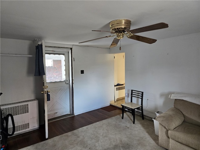 sitting room with ceiling fan, wood-type flooring, and radiator heating unit