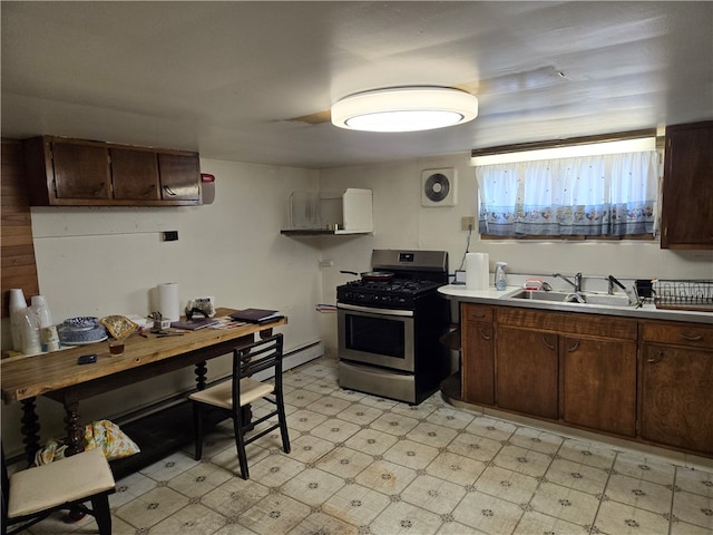 kitchen featuring sink, gas stove, dark brown cabinets, and light tile patterned flooring