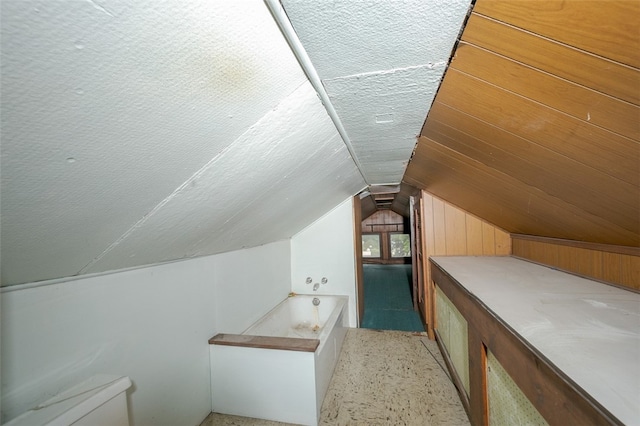 additional living space with a textured ceiling and lofted ceiling