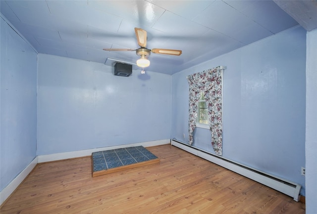 spare room featuring ceiling fan, light hardwood / wood-style floors, and a baseboard radiator