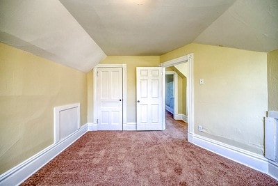 additional living space with lofted ceiling and carpet