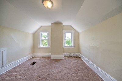 additional living space with carpet flooring and vaulted ceiling