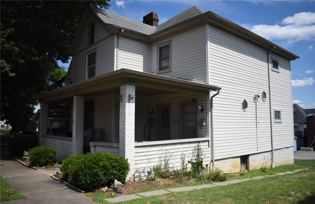 14 S 5th St, Youngwood, PA 15697 - view of home's exterior with covered porch and a chimney