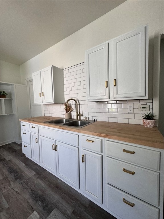 kitchen with dark hardwood / wood-style flooring, backsplash, white cabinetry, wood counters, and sink