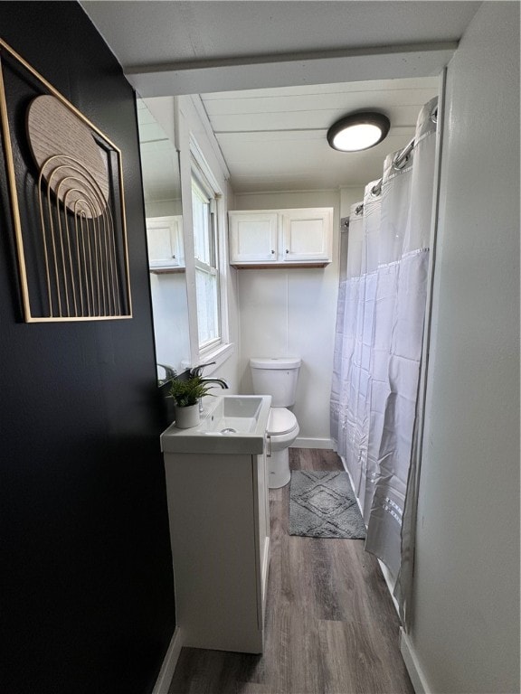 bathroom featuring wood-type flooring, vanity, and toilet