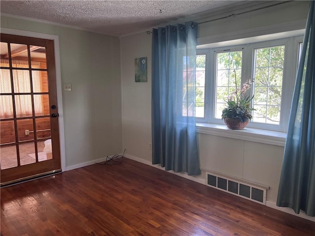 unfurnished room featuring ornamental molding, dark hardwood / wood-style flooring, and a textured ceiling