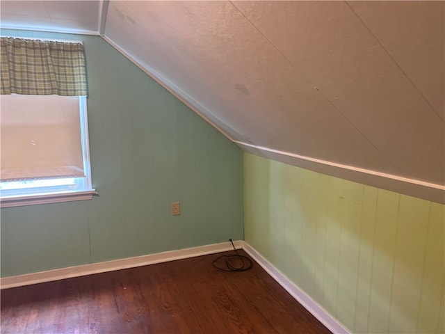 additional living space featuring hardwood / wood-style floors and vaulted ceiling