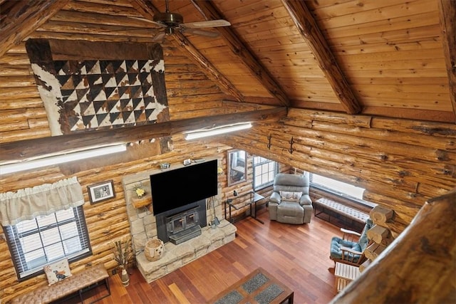 unfurnished living room featuring hardwood / wood-style floors, wooden ceiling, vaulted ceiling with beams, ceiling fan, and log walls