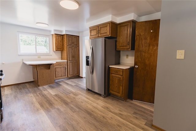 kitchen with light hardwood / wood-style floors and stainless steel fridge