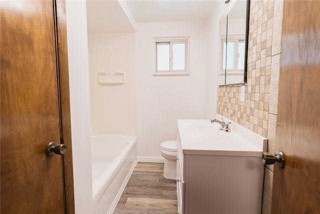 full bathroom featuring toilet, hardwood / wood-style floors, tile walls, shower / tub combination, and vanity