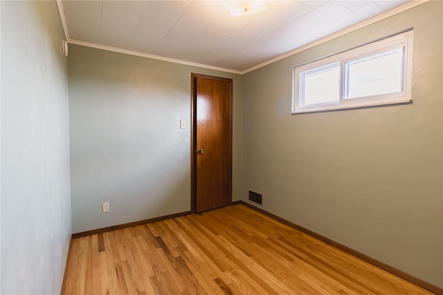 spare room with light wood-type flooring and crown molding