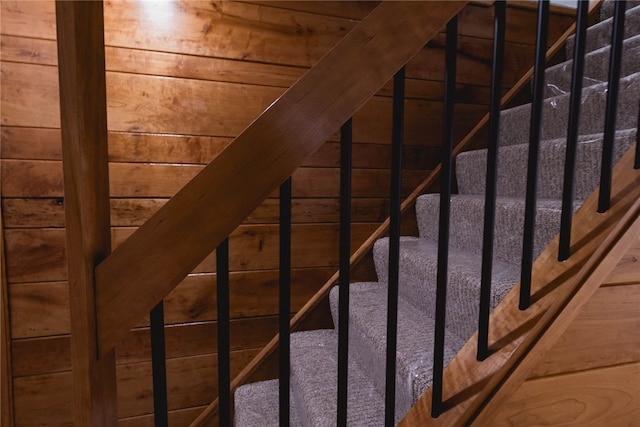 staircase featuring wood walls