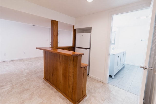 kitchen with white fridge and light tile patterned floors