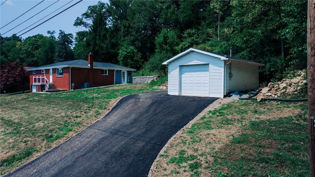 exterior space with a front yard, a garage, and an outdoor structure