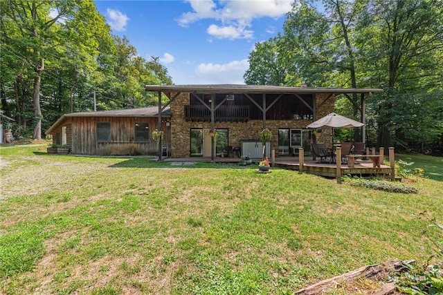 rear view of property with a deck and a lawn