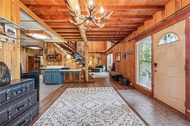 foyer with wooden ceiling, wood walls, dark wood-type flooring, and a chandelier