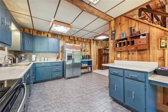 186 Lake Road Ln, Middlecreek Twp, PA 15557 - kitchen with wooden walls, blue cabinets, a sink, stainless steel fridge with ice dispenser, and decorative backsplash