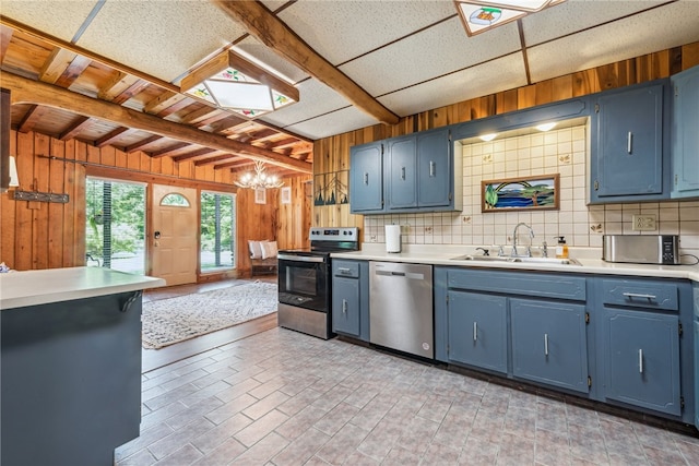 kitchen with stainless steel appliances, light tile patterned floors, sink, tasteful backsplash, and a chandelier