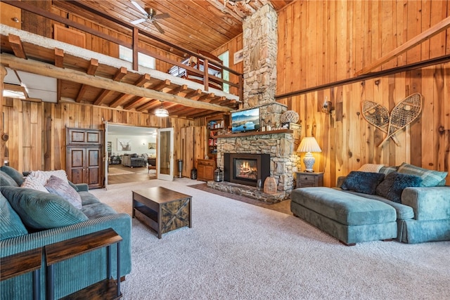 carpeted living room featuring wood walls, a fireplace, wood ceiling, and ceiling fan