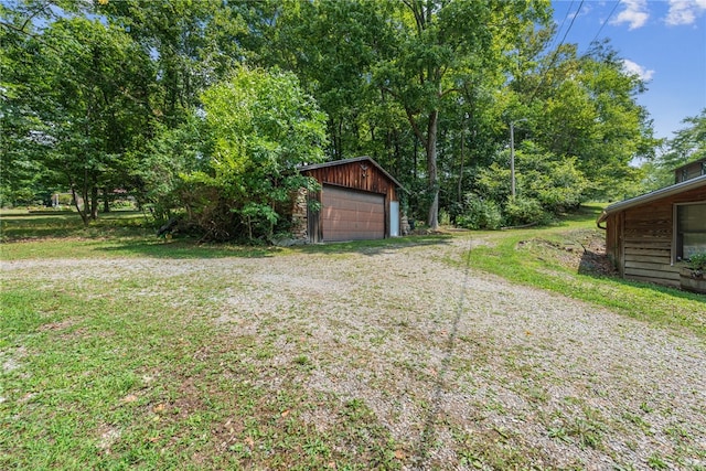 view of yard featuring a garage and an outbuilding