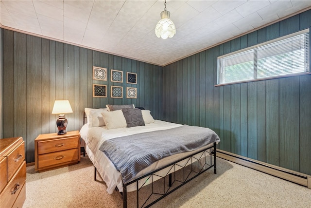 carpeted bedroom featuring baseboard heating and wood walls