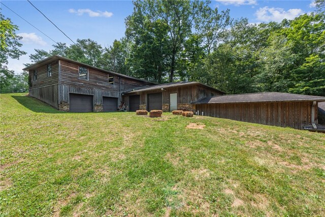 back of property with a lawn and a garage