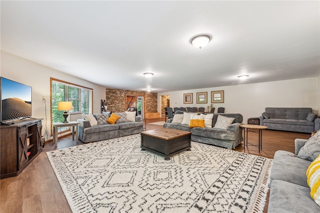 living room with wood-type flooring and brick wall