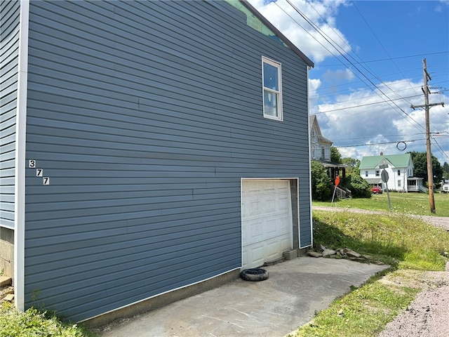 view of property exterior with a garage and a lawn