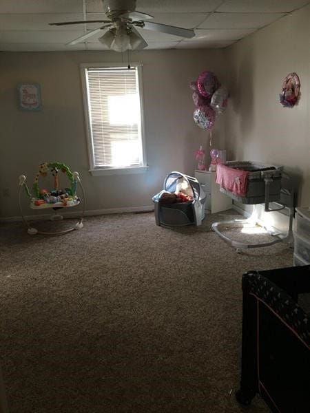 interior space featuring ceiling fan, a paneled ceiling, and carpet flooring