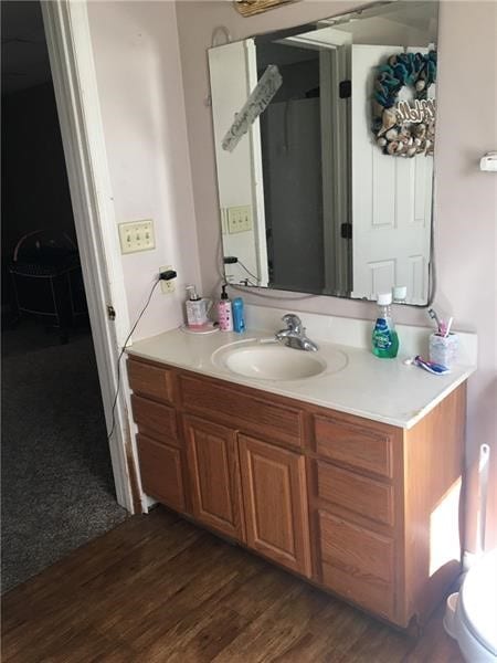 bathroom with wood-type flooring, vanity, and toilet