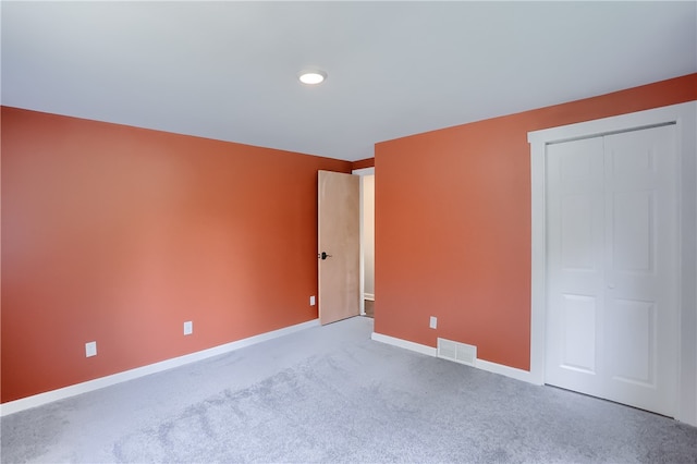 unfurnished bedroom featuring carpet flooring and a closet