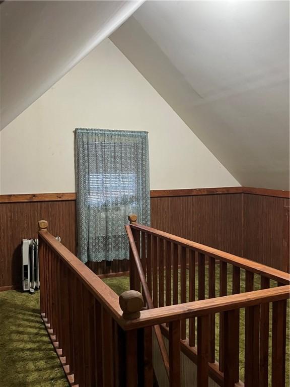 interior space featuring vaulted ceiling and dark colored carpet