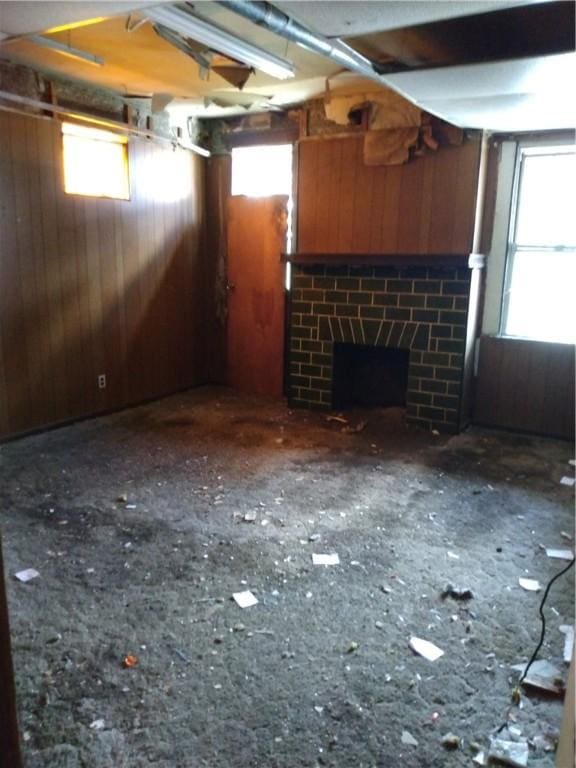 unfurnished living room with wood walls and a fireplace