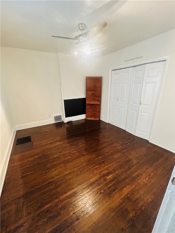 unfurnished bedroom with ceiling fan, wood-type flooring, and a closet