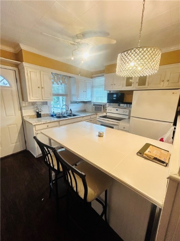 kitchen with white appliances, white cabinets, ornamental molding, and decorative light fixtures