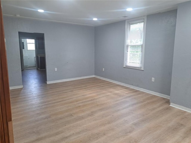 empty room with a healthy amount of sunlight and light hardwood / wood-style flooring